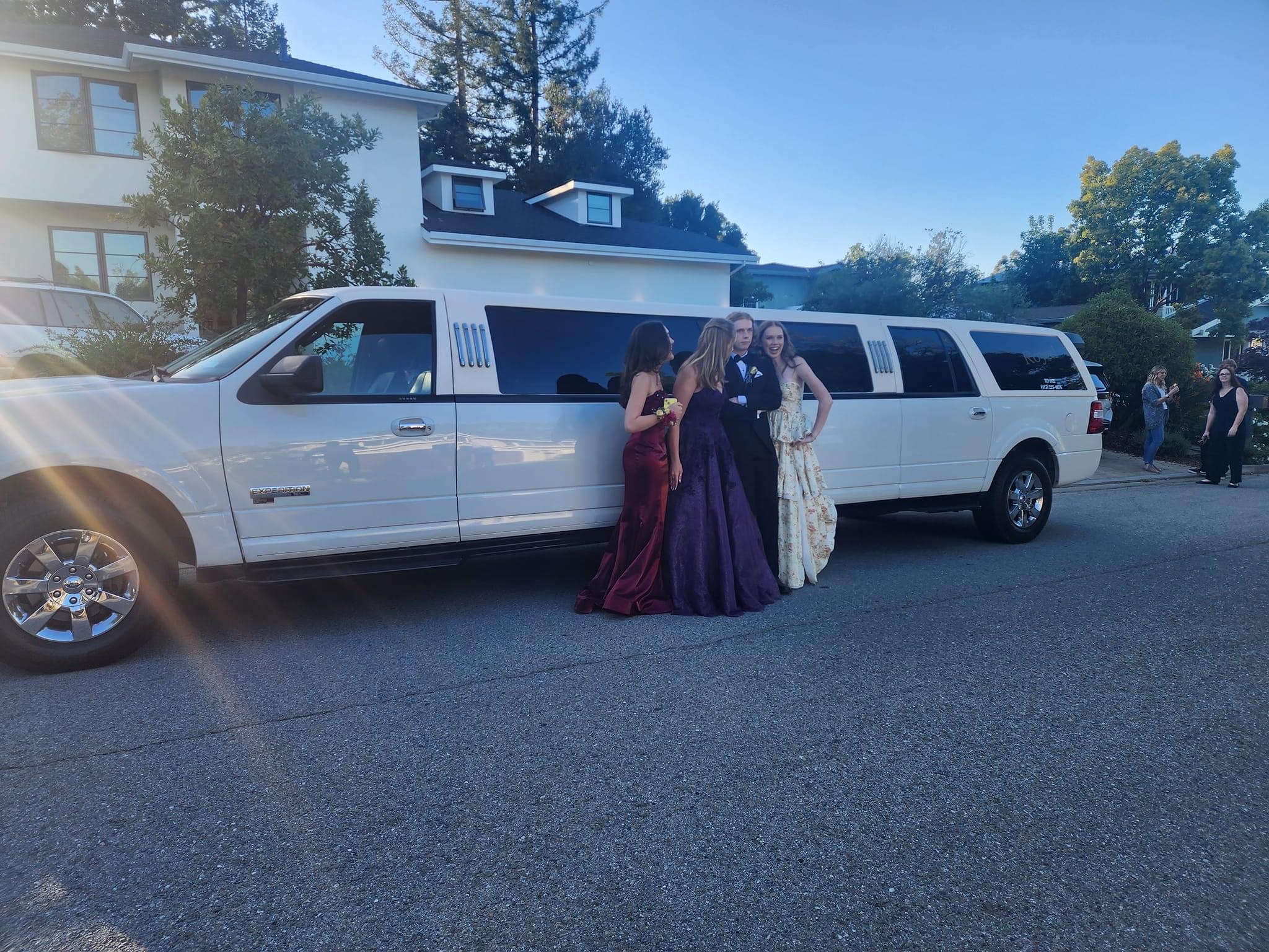 A group of individuals standing beside a black limousine, provided by a professional car service.